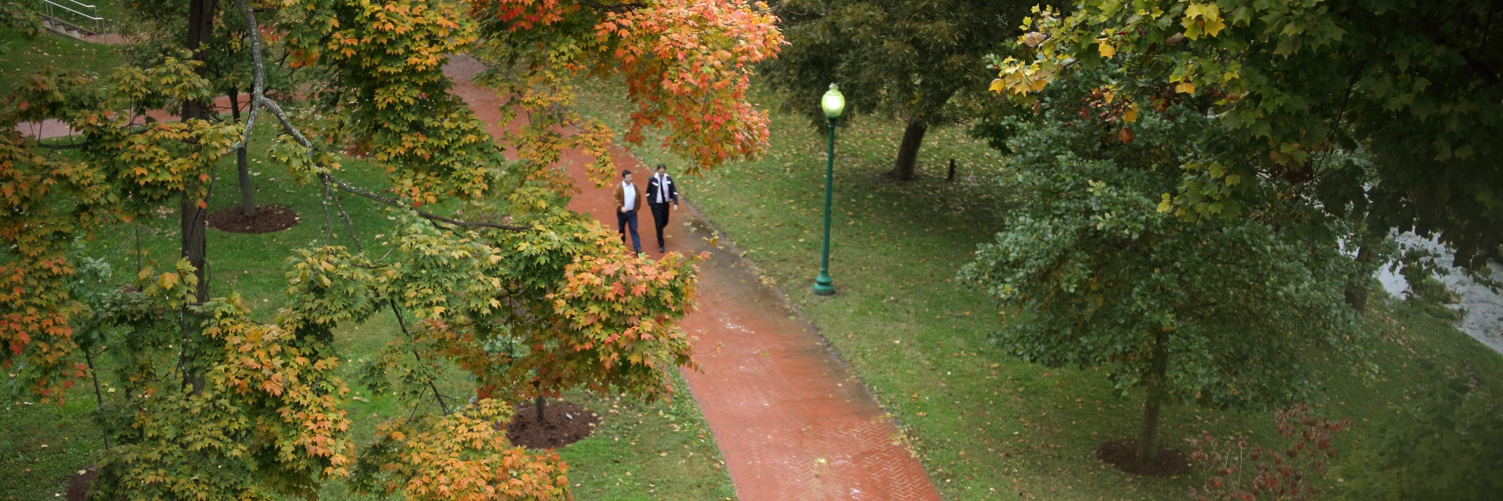 Two people walking down a sidewalk on the Bloomington campus