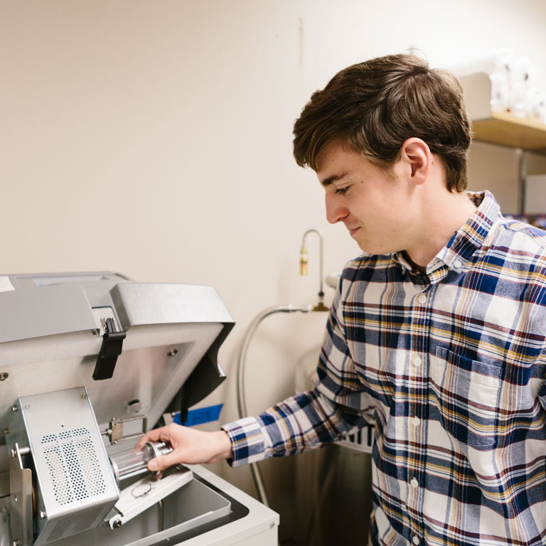 Student with machinery in a lab